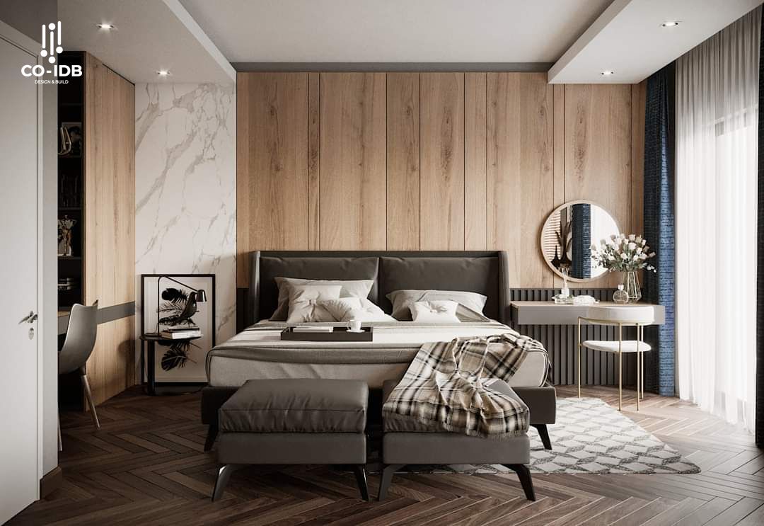 Không gian phòng ngủ hiện đại với vách đầu giường ốp gỗ chạy full chiều cao, sàn xương cá nâu trầm và nội thất tối giản, nhấn bằng đường nét thẳng – bảng màu trung tính thanh lịch.
