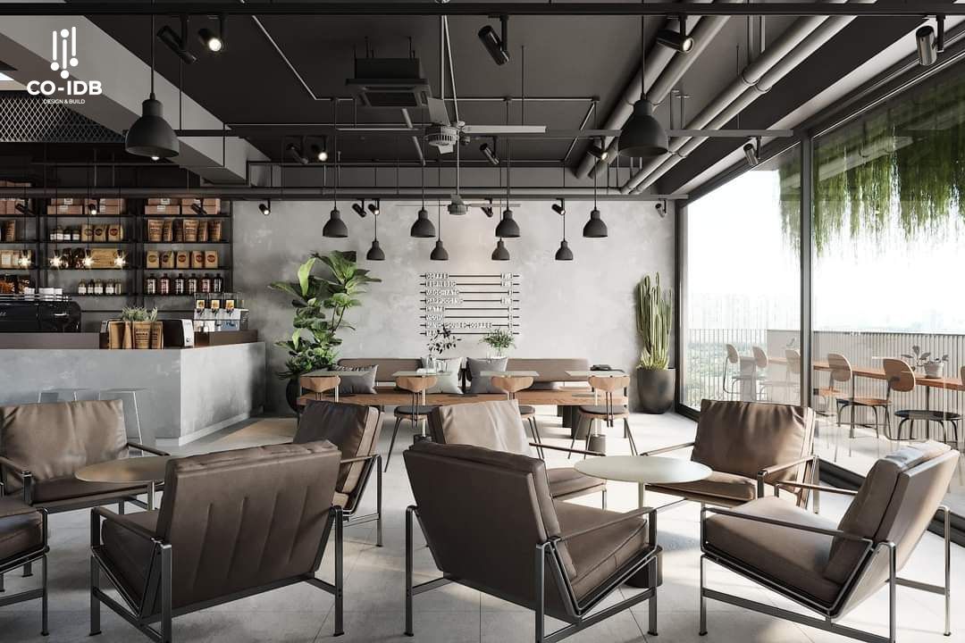 Không gian nội thất quán cà phê Urban Coffee với trần mở lộ hệ kỹ thuật, kết hợp bàn ghế nệm da và cây xanh tạo điểm nhấn gần gũi – đậm chất urban chic.