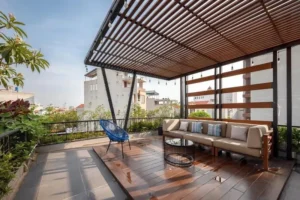 Sân thượng phong cách nhiệt đới Tropical Garden với mái lam gỗ, sofa ngoài trời và nhiều cây xanh
