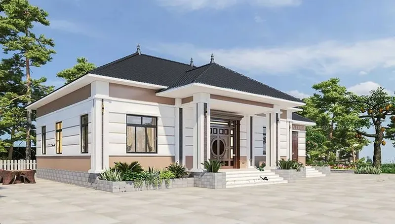 Mẫu nhà cấp 4 mái Nhật màu trắng phối nâu nhạt, cửa chính bằng gỗ có ô kính tròn, bậc tam cấp rộng và khoảng sân bê tông thoáng đãng.