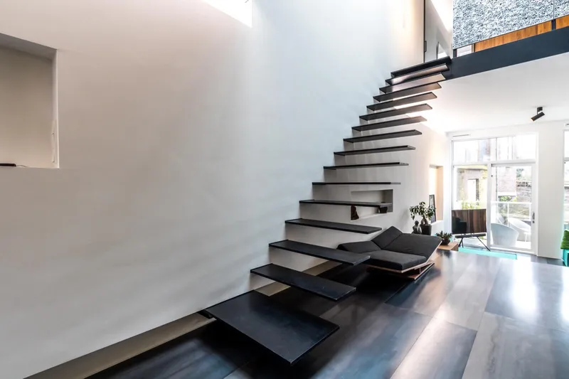 Thiết kế cầu thang sắt dạng bay (floating staircase) độc bản, không trụ đỡ, tạo hiệu ứng thị giác lơ lửng đầy nghệ thuật