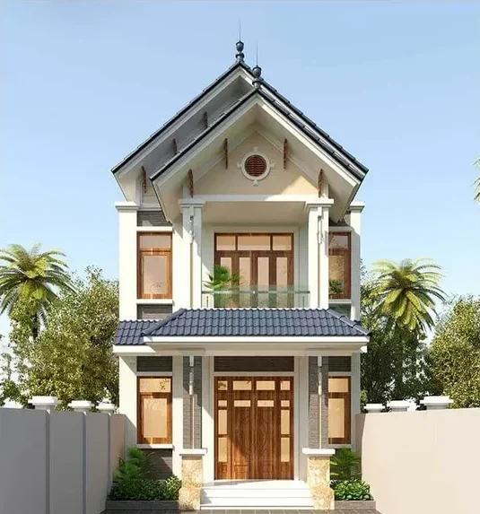 Mẫu nhà ống 2 tầng mái Thái hiện đại màu trắng kem phối xám ghi, mặt tiền lắp hệ cửa gỗ kính ấm cúng và ban công tầng 2 sử dụng lan can kính cường lực thông thoáng.