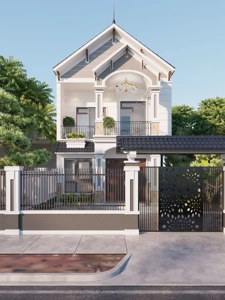 Mẫu nhà phố 2 tầng mái Thái tân cổ điển màu trắng phối xám, mặt tiền nổi bật với cổng sắt CNC hoa văn đen nghệ thuật, hàng rào kiên cố và ban công có đèn chùm sang trọng.