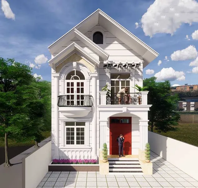 Mẫu nhà phố 2 tầng mái Thái mặt tiền 7m tân cổ điển màu trắng kem, nổi bật với cửa chính màu đỏ, hệ ban công sắt nghệ thuật và cửa sổ vòm cong.