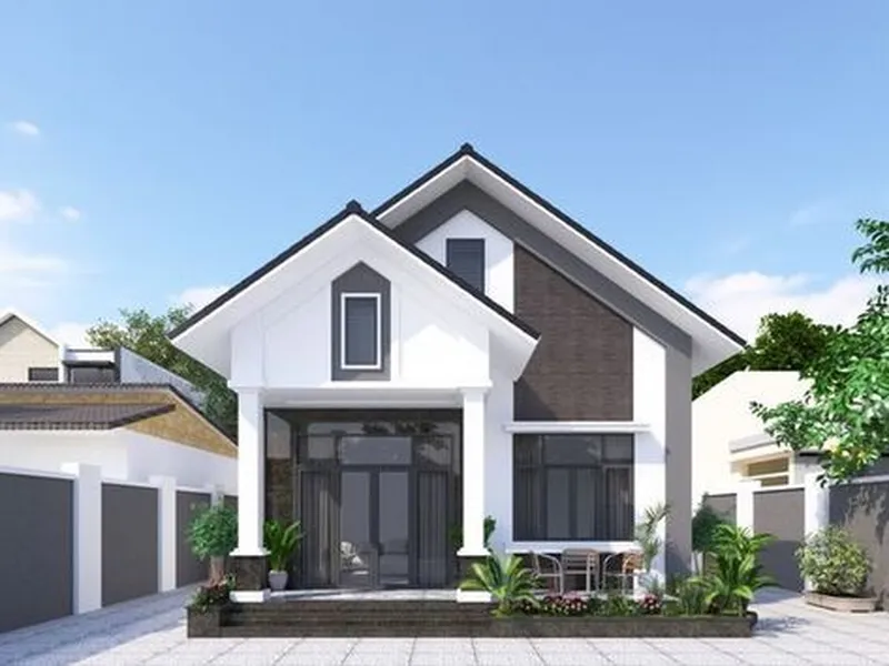 Mẫu nhà cấp 4 mái Thái đơn giản hiện đại màu trắng phối xám đen, mặt tiền hai gian lắp cửa kính khung tối màu và có góc sân đặt bàn trà nhỏ.