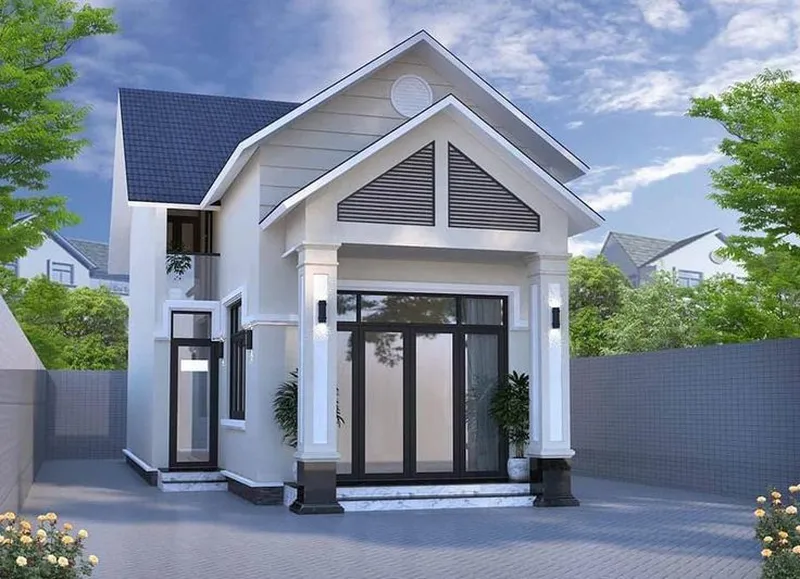 Mẫu nhà gác lửng mái thái hiện đại sơn màu kem nhạt, có hệ cửa nhôm kính đen lớn ở mặt tiền, cột sảnh vuông kiên cố và ô thoáng chữ A ốp lam xám độc đáo.