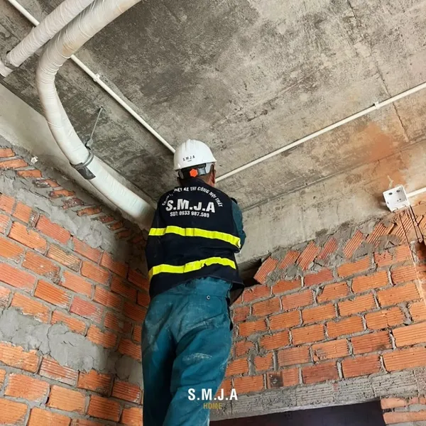 Công nhân đang lắp đặt đường ống kỹ thuật và hệ thống điện đi nổi trên trần nhà tại công trình nhà ống.